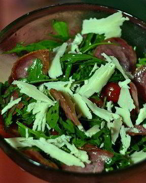 Теплый салат с рукколой, помидорами черри, жареными колбасками Сольчечон и пармезаном