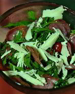 Теплый салат с рукколой, помидорами черри, жареными колбасками Сольчечон и пармезаном